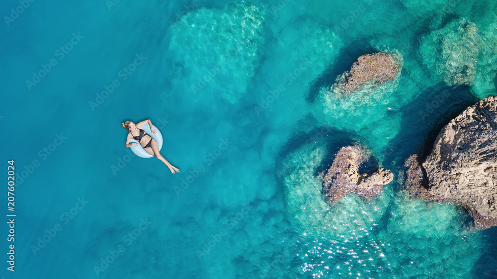 Wall mural aerial view at the girl on sea surface. beautiful composition at the summer time