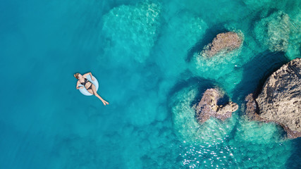 Aerial view at the girl on sea surface. Beautiful composition at the summer time - obrazy, fototapety, plakaty