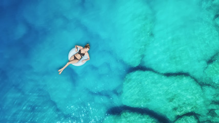 Aerial view at the girl on sea surface. Beautiful composition at the summer time