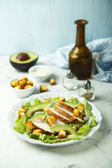 Grilled chicken Caesar salad with avocado