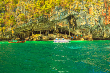 Boats visit Viking Cave, north of Piley Bay, one of main tourist attractions of Ko Phi Phi Leh, near Maya Bay, Phi Phi Islands, Thailand. Inside the cave, there are thousands of nestles of swifts.