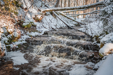 Close up of cascade. Soft focus. Winter creek on the Ogre river. Latvia. Baltic.