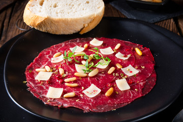 Carpaccio of beef with pine nuts, colorful pepper and Parmesan cheese
