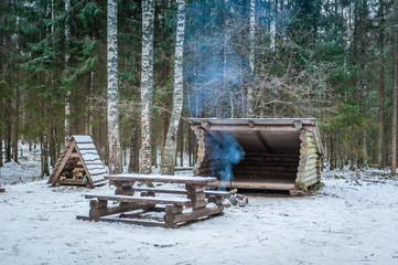 Picnic site with wooden table and benches in winter forest.  Estonia.