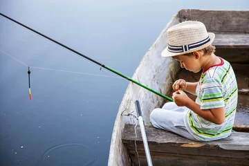 Fotobehang Young fisherman catching fish on fish-rod © Photozi
