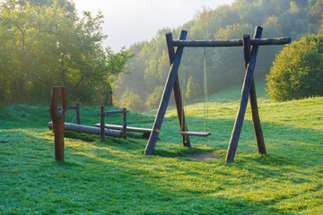 wooden children playground in highland green landscape.