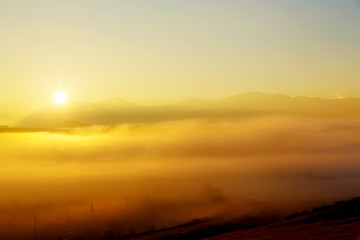 A beautiful morning landscape with road and sunshine and fog.