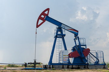 Fototapeta na wymiar Working oil rig in a cornfield