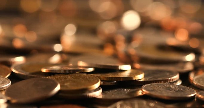 pan shot of close up money coin stacking on  the floor in dark light , business and financial for money saving or the investment background concept  , extremely close up and shallow DOF