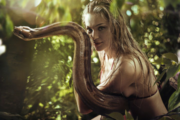 Portrait of a pretty blonde holding a wild snake