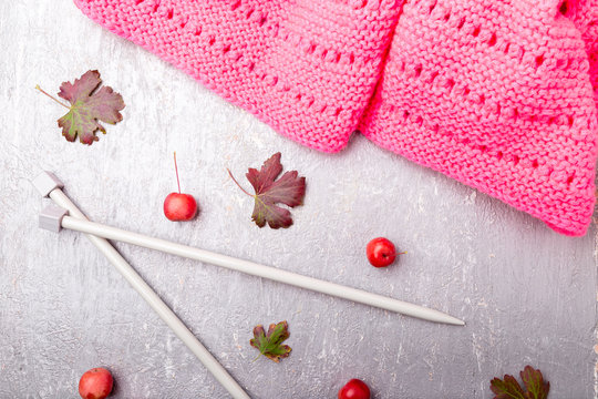 Pink scarf near knitting needles