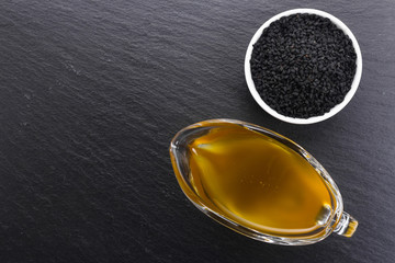 grains of black cumin and oil on the rustic background