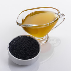 grains of black cumin and oil on the rustic background