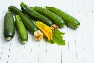 zucchini vegetables with flower on white wooden table