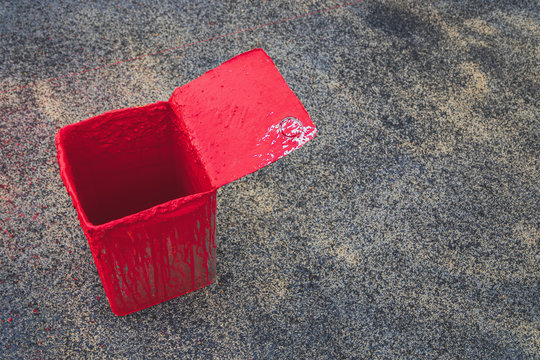 Buckets of red paint used on the road with copy space.