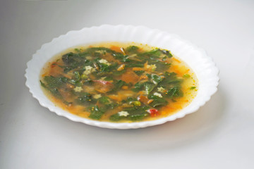 Green soup with sorrel and nettle in a white plate. Russian traditional nettle soup.