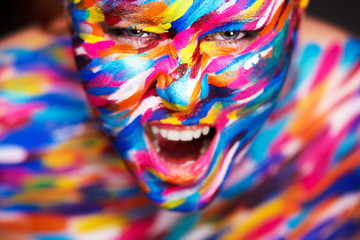 Obraz na płótnie Canvas Portrait of the bright beautiful girl with art colorful make-up and bodyart