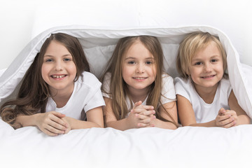 Three children under blanket