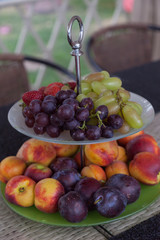 Fresh summer fruits. Organic and natural fruit on tray. Fresh grapes, cheaches, plums and strawberry. Healthy eating.