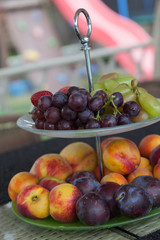 Fresh summer fruits. Organic and natural fruit on tray. Fresh grapes, cheaches, plums and strawberry. Healthy eating.