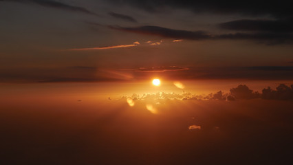 The red sunset of the sun in the sky OVER THE CLOUDS