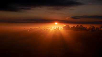 The red sunset of the sun in the sky OVER THE CLOUDS