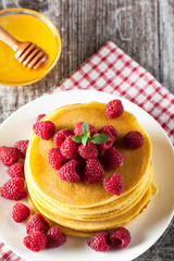 Fresh made delicious pancakes with berries, blackberries, raspberries, banana, honey and maple syrup. Healthy morning breakfast concept.