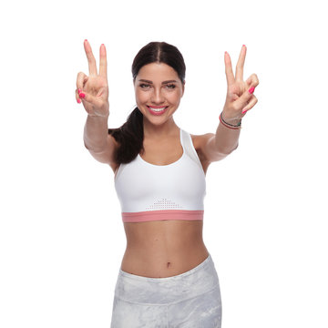 portrait of beautiful fitness woman making peace sign