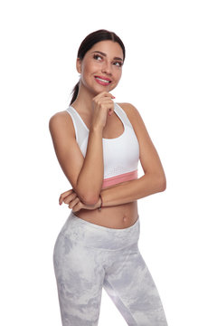 pensive fitness woman looks up to side while smiling