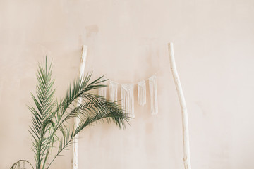 Minimal home interior design. Tropical palm branches and boho decoration at pastel beige wall. Modern studio concept. © Floral Deco