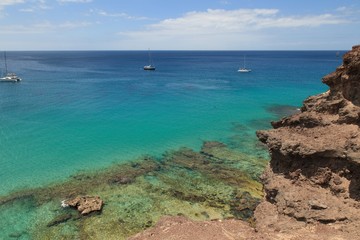 Fototapeta na wymiar A beautiful coastline of the Atlantic ocean with sailboats in Morro Jable Fuerteventura- Canary Islands