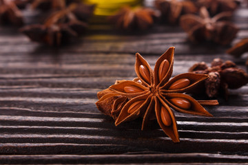 essential oil of the anise stars on a dark rustic background