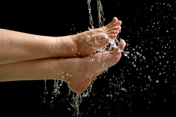 Fototapeta premium Woman's foots with water splash