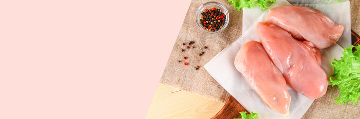 raw chicken fillets on wooden cutting board.