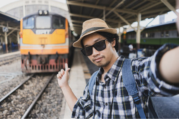 Asian man bag pack tourist take a selfie in railway station at Thailand.