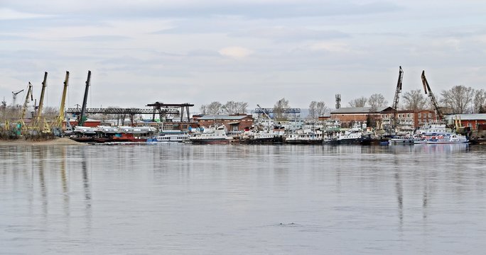 Shipyard in Irkutsk / IRKUTSK, RUSSIA - April 11, 2018: Viewed to cargo shipyard of Irkutsk city along Angara river, Siberian area. Lots of ships park for maintenance and transferring