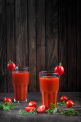 Tomato juice on dark wooden background