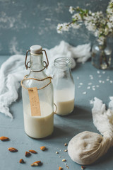 Vegan non-dairy almond milk in glass bottles on wooden background