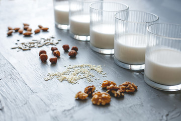 Different kinds of vegan non-dairy milk in glasses on wooden background, selective focus