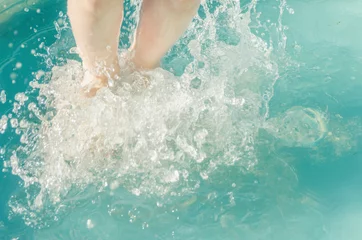 Fototapeten close-up, baby feet in the water in a jump spray © dmitrypk