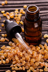 frankincense essential oil on a wooden background