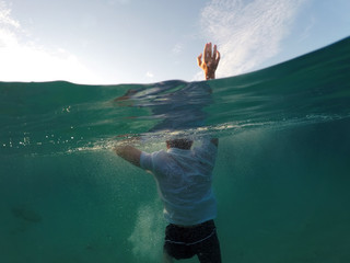 young man sinking into the sea