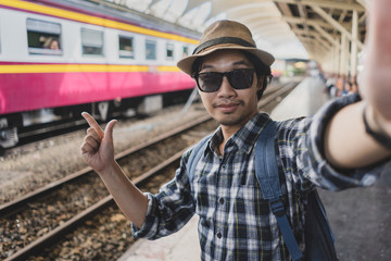 Asian man bag pack tourist take a selfie in railway station at Thailand.