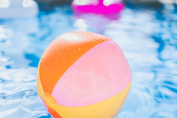 colorful Beach ball floating in swimming pool. Abstract concept of summer vacations, relaxation and have fun in the sunshine day