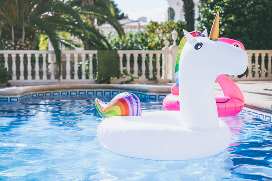Inflatable colorful white unicorn at the swimming pool. Fun time in the Summer at swimming pool. concept