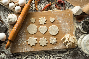 Preparation of shaped cookies from raw dough on the wooden board. top-view
