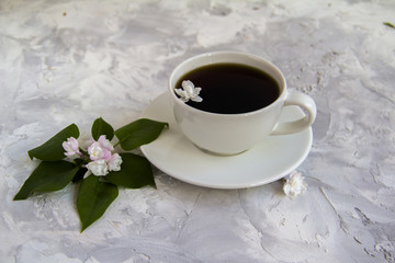 Cup of coffee serving with lilac and leaves