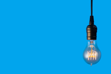 Edison light bulb on blue background. space for text