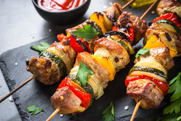 Grilled shish kebab with vegetables  on black.