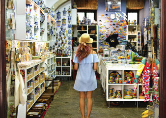 Blonde woman in souvenir shop in Lisbon, Portugal - obrazy, fototapety, plakaty